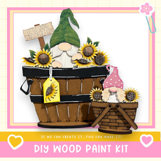 a DIY wood paint kit for creating a wooden gnome and a wooden basket filled with sunflowers. The kit includes a wooden gnome and a wooden basket, both decorated with sunflowers. The kit is presented in a wooden frame, and the text "If we can create it, you can make it!" encourages viewers to try the kit themselves.