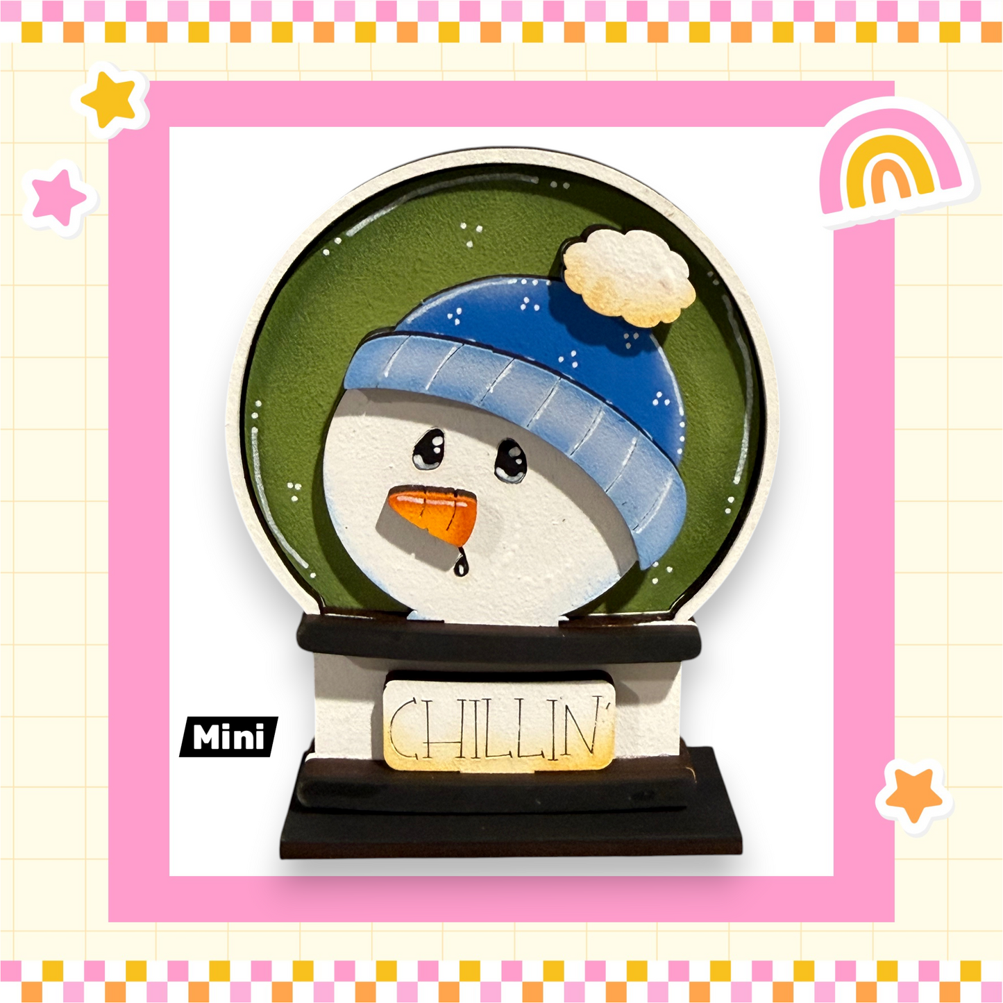 A snowman figurine with a blue hat and a carrot nose, sitting inside a mini snow globe.