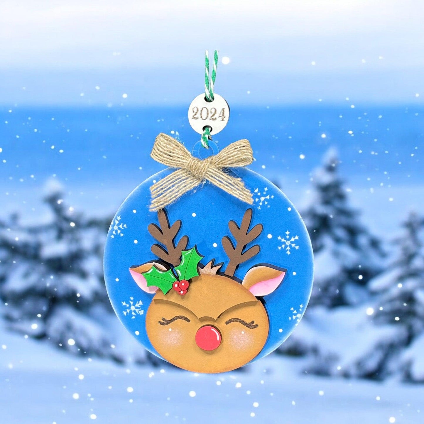 a christmas ornament hanging from a tree in the snow