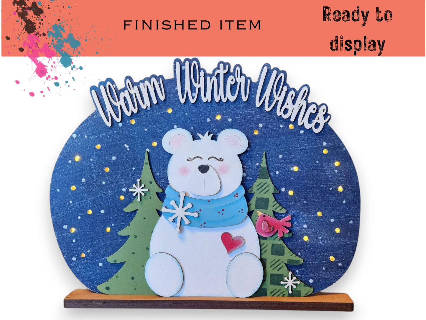 A decorative snow globe featuring a white polar bear surrounded by snowflakes and trees, with the text "Warm Winter Wishes" written above it.