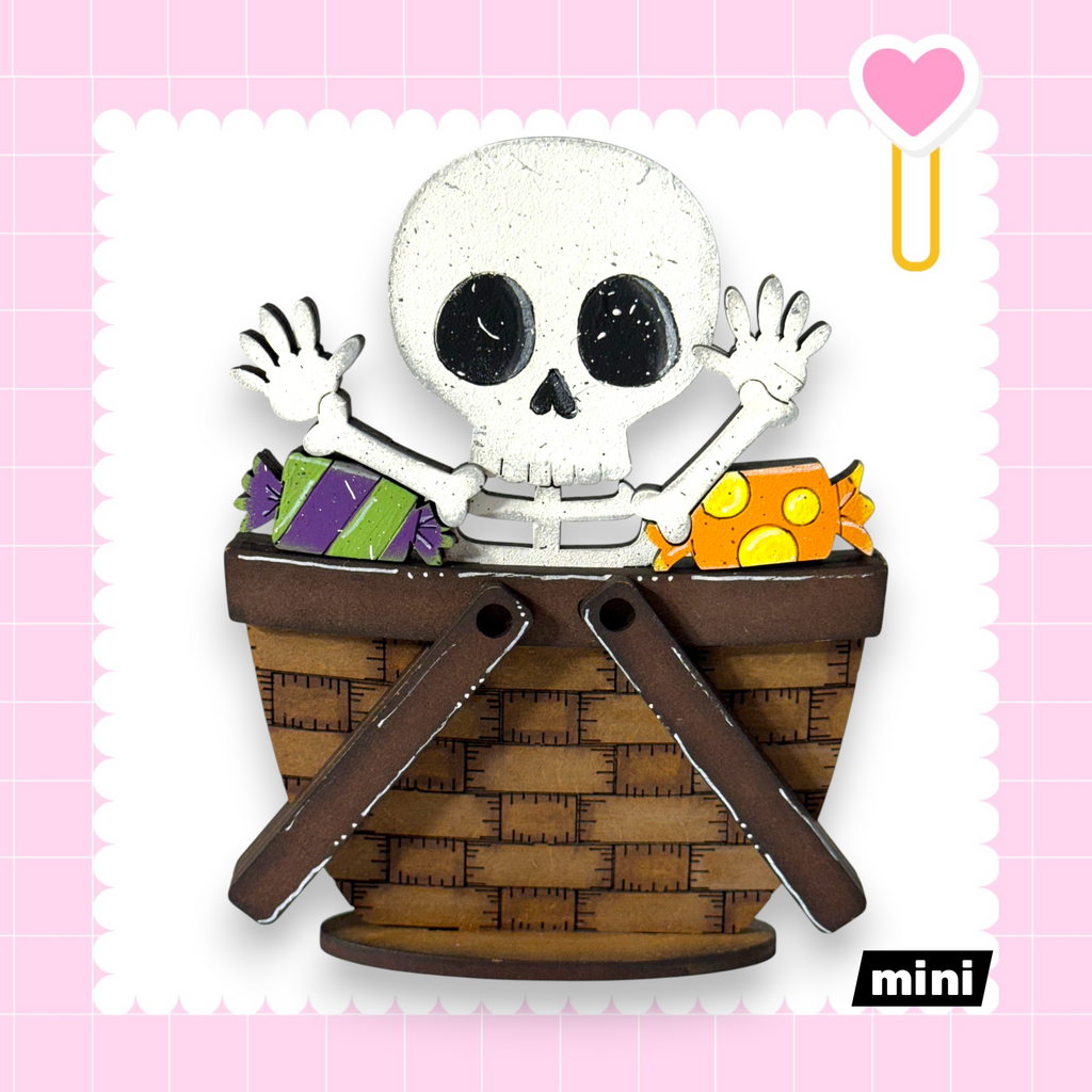 A skeleton toy is sitting in a basket filled with candy, creating a playful and spooky scene.