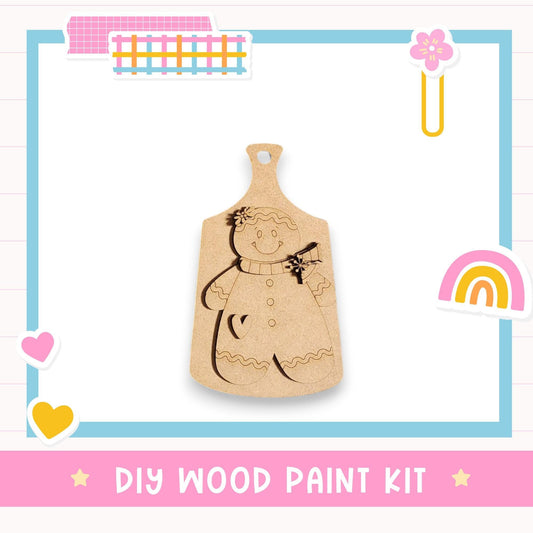 a DIY wood paint kit, including a wooden cutout of a smiling gingerbread man and various colorful stickers surrounding it.