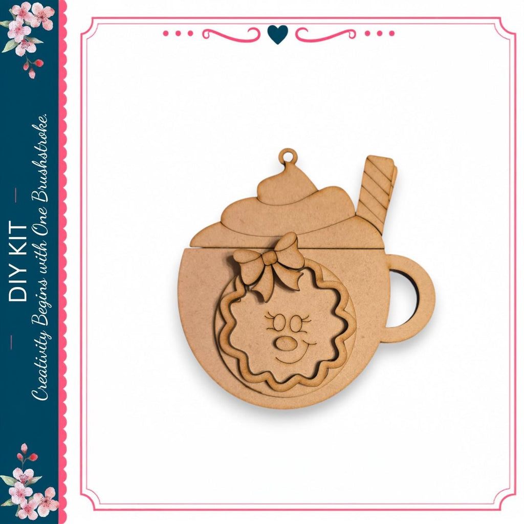 A wooden ornament in the shape of a cup with a smiley face and a wreath on top, sitting on a white background.