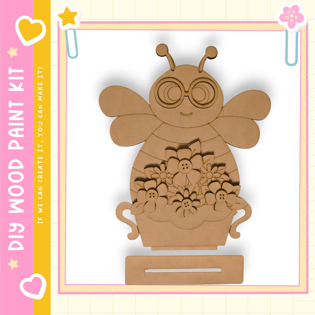 A wooden paint kit depicting a bee with flowers in a vase, set against a pink and yellow background with decorative elements.