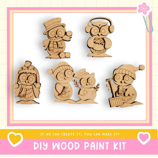a DIY wood paint kit with five wooden owl figurines in various poses, including one wearing a hat and another holding a stick. The kit appears to be designed for creating wooden decorations or toys.