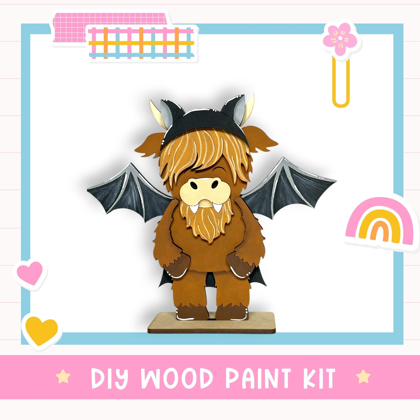 A wooden toy figure of a dragon-like creature with wings and horns, wearing a hat, is displayed in the center of the image. The text "DIY WOOD PAINT KIT" is visible, indicating that this is a DIY wood paint kit for creating a wooden toy figure.