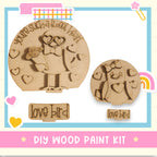 The image is a DIY wood paint kit featuring two wooden bird-shaped figures, one larger and one smaller, with hearts and a bow around them. The kit is labeled "Love Bird" and includes a sign that says "DIY WOOD PAINT KIT".