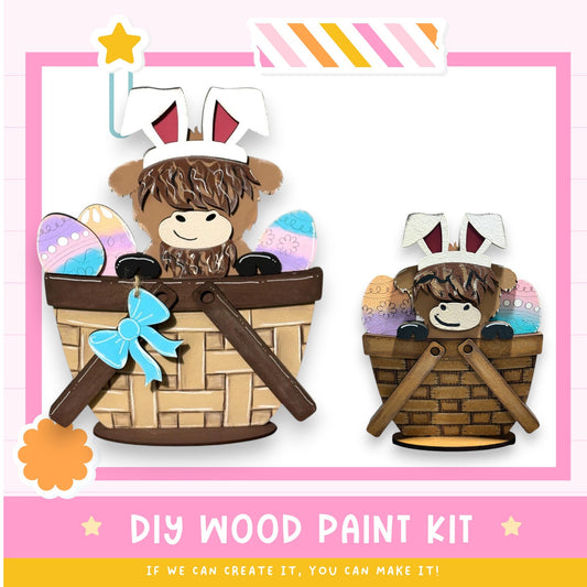 two wooden Easter baskets, each containing a small toy bunny wearing a bunny hat. The baskets are decorated with colorful Easter eggs and ribbons. The image also includes text that reads "DIY WOOD PAINT KIT" and "If we can create it, you can make it!"