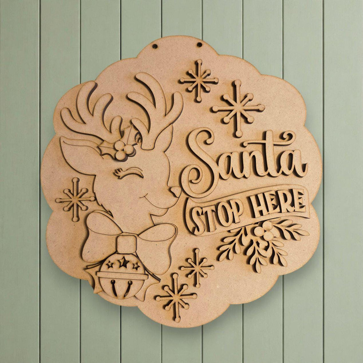 A wooden sign with a deer head and snowflakes, along with the text "Santa Stop Here" in a decorative font.