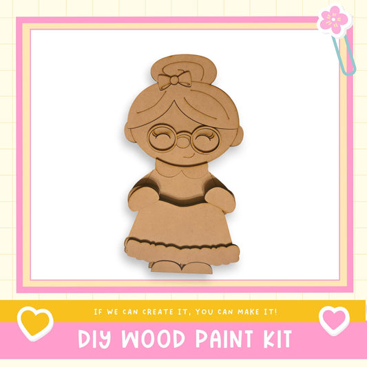 a DIY wood paint kit, with a wooden doll or character in the center. The kit is presented in a pink and yellow frame, and the text "If we can create it, you can make it!" is displayed below the image.