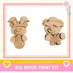 two wooden animal figures, a bunny and a bear, with a pink and white border. The text below the image reads "DIY WOOD PAINT KIT" and "If we can create it, you can make it!"