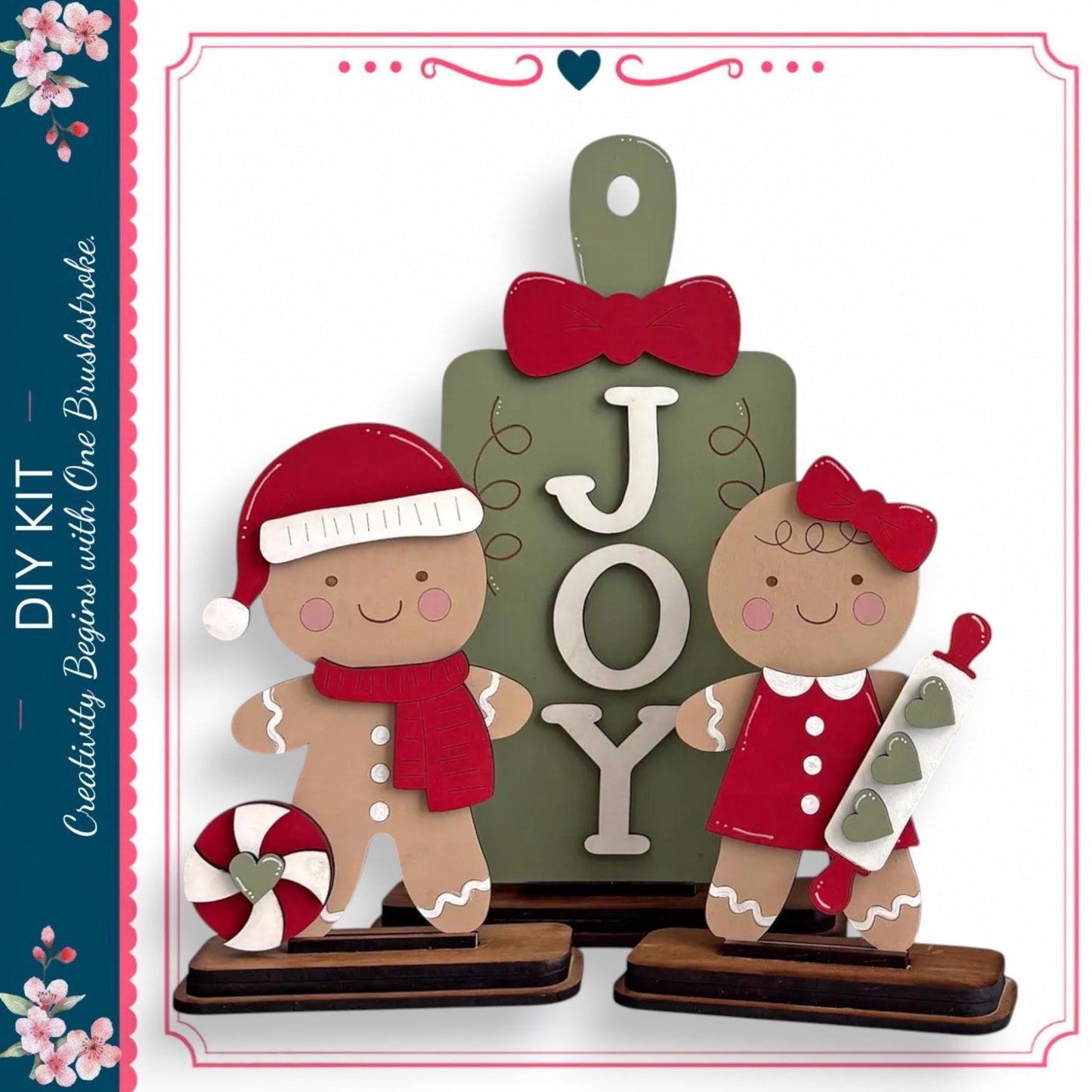 two gingerbread men, one wearing a red hat and the other wearing a red dress, standing in front of a green sign with the word "JOY" written on it.