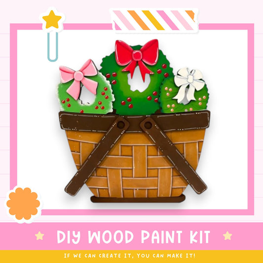 A DIY wood paint kit with a basket containing a wreath, ribbon, and flowers, along with a star and a flower icon.