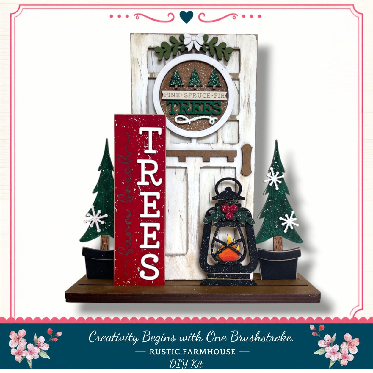 A rustic farmhouse-style DIY kit featuring a decorative door, a lantern, and two small Christmas trees. The kit is titled "Creativity Begins with One Brushstroke" and includes a "RUSTIC FARMHOUSE DIY KIT".