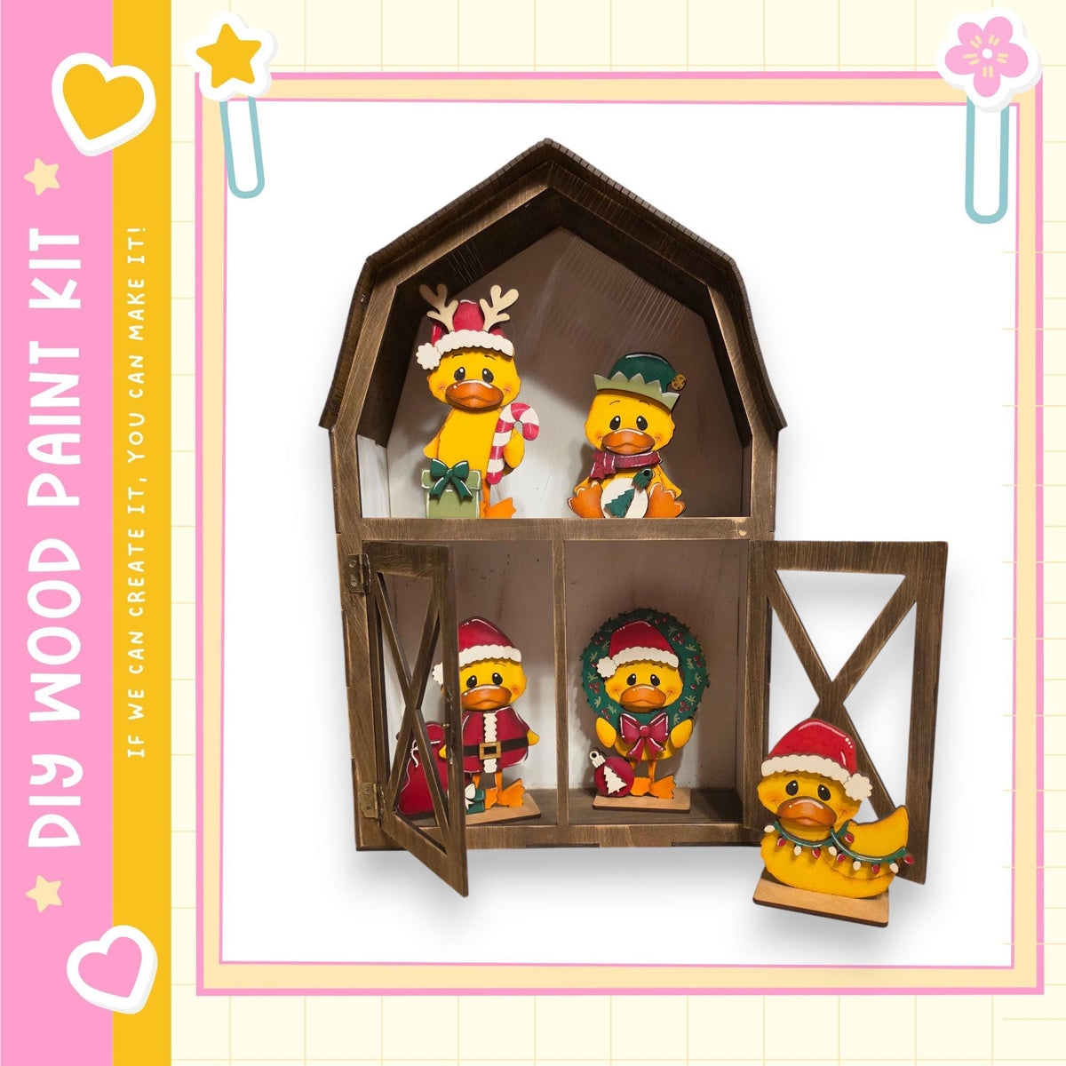 A wooden barn-shaped display case containing four small figurines, each wearing a festive hat and scarf, with one of the figures holding a wreath.