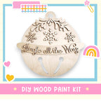 a wooden christmas ornament with a rainbow in the background
