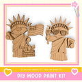 two cardboard cutouts of the Statue of Liberty, one holding an American flag and the other holding a torch, set against a pink and white background.