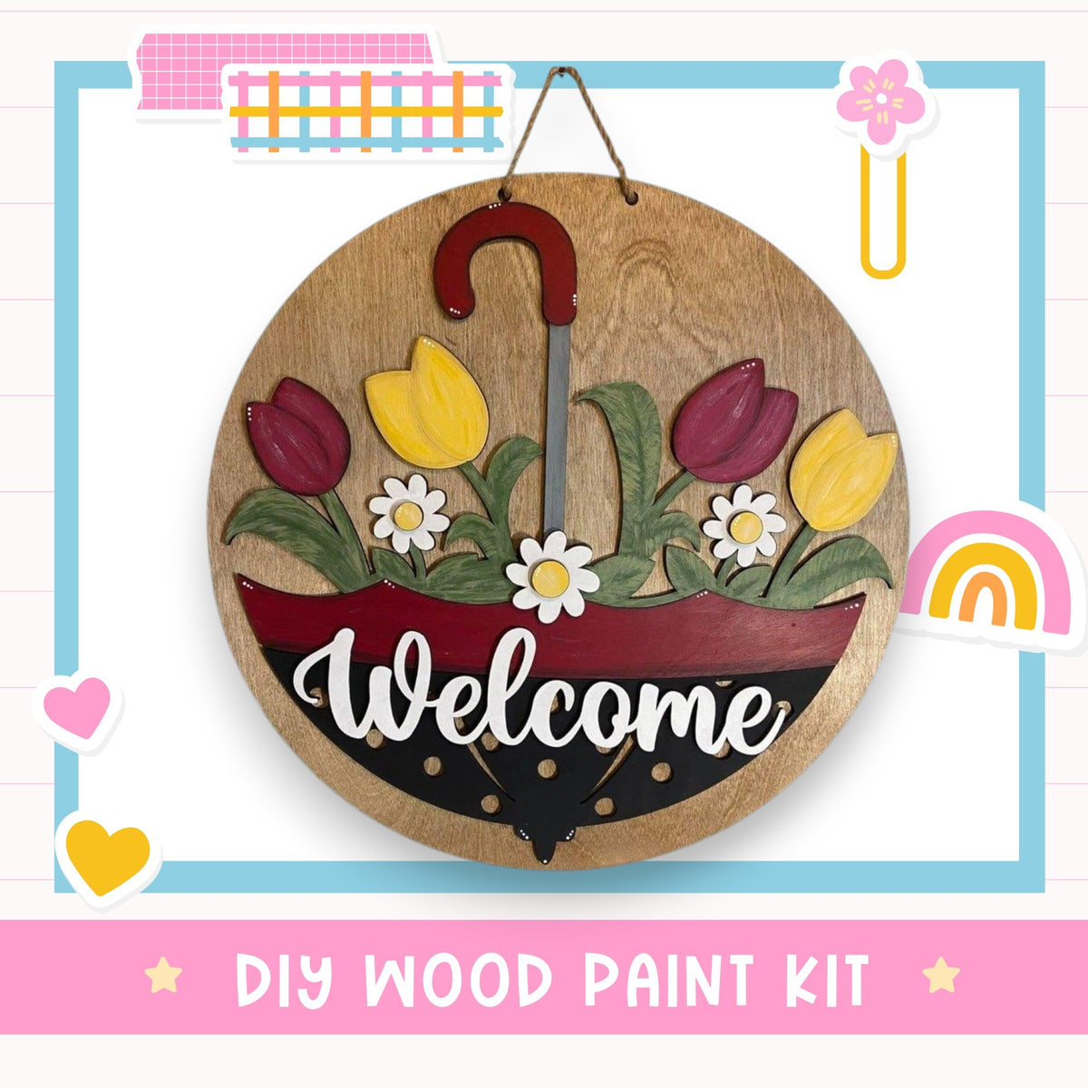 A wooden sign with a red umbrella handle and flowers, displaying the word "Welcome" in white cursive text. The sign is hanging on a wall, surrounded by various colorful stickers and illustrations.
