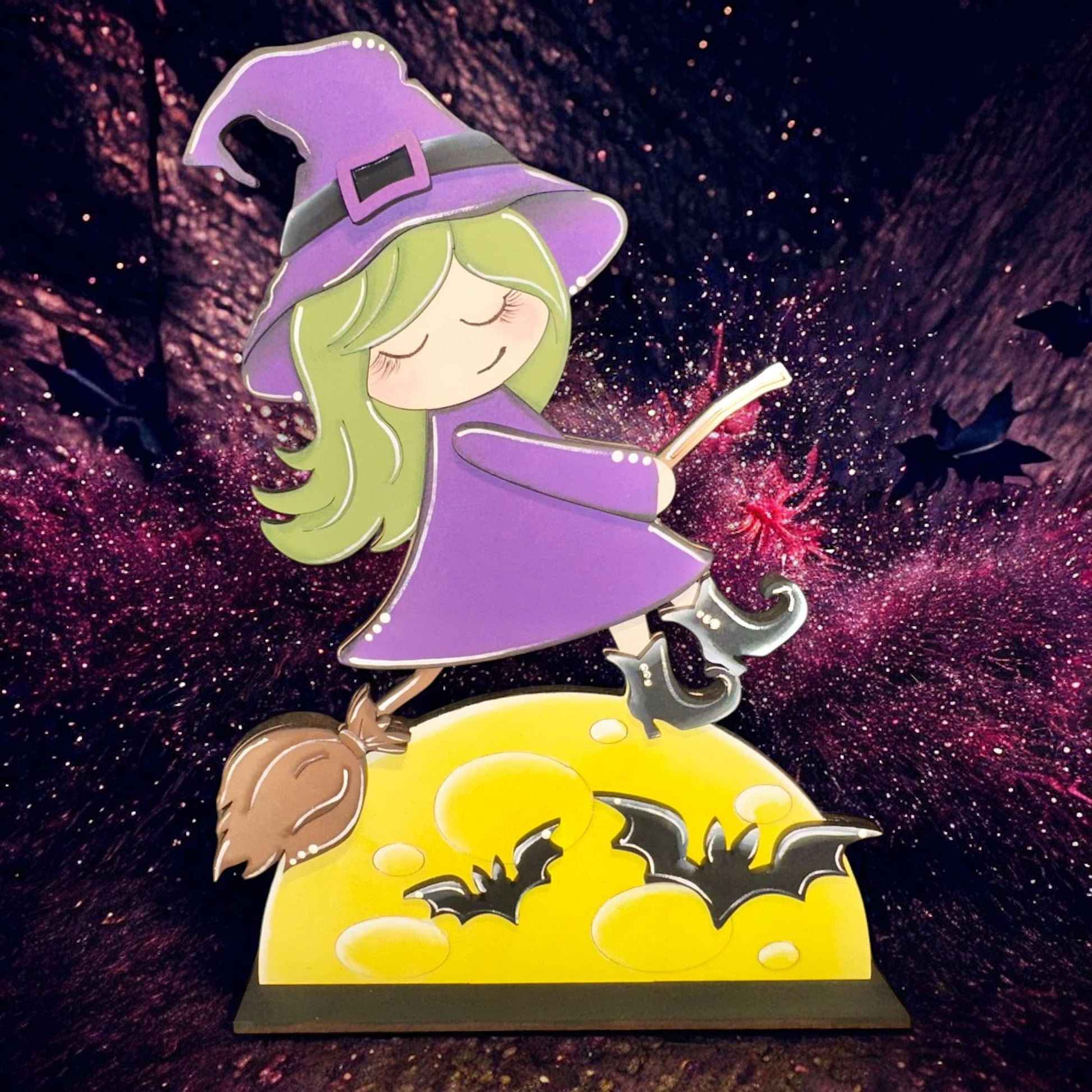 a girl in a witches costume on top of a hill