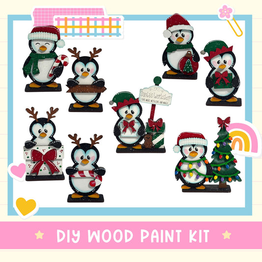 The image is a collage of various Christmas-themed penguin figurines, including one with a Santa hat, another with a reindeer, and a third one with a Christmas tree. The penguins are posed in different ways, such as standing, sitting, and interacting with each other. The image also includes a sign that reads "DIY WOOD PAINT KIT" and a rainbow, suggesting that the penguins are part of a festive display.