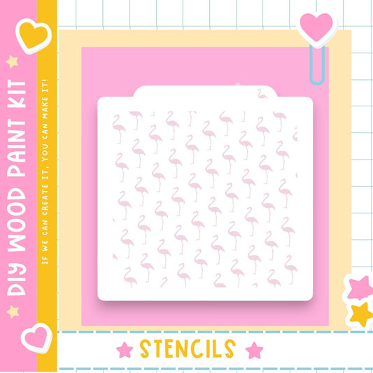The image is a colorful and playful DIY paint kit featuring a pink background with a repeating pattern of pink flamingos. The kit includes a stencil and a heart-shaped clip, and the text "DIY WOOD PAINT KIT" and "STENCILS" is visible, indicating that the kit is designed for creating art with the stencil and heart-shaped clip.