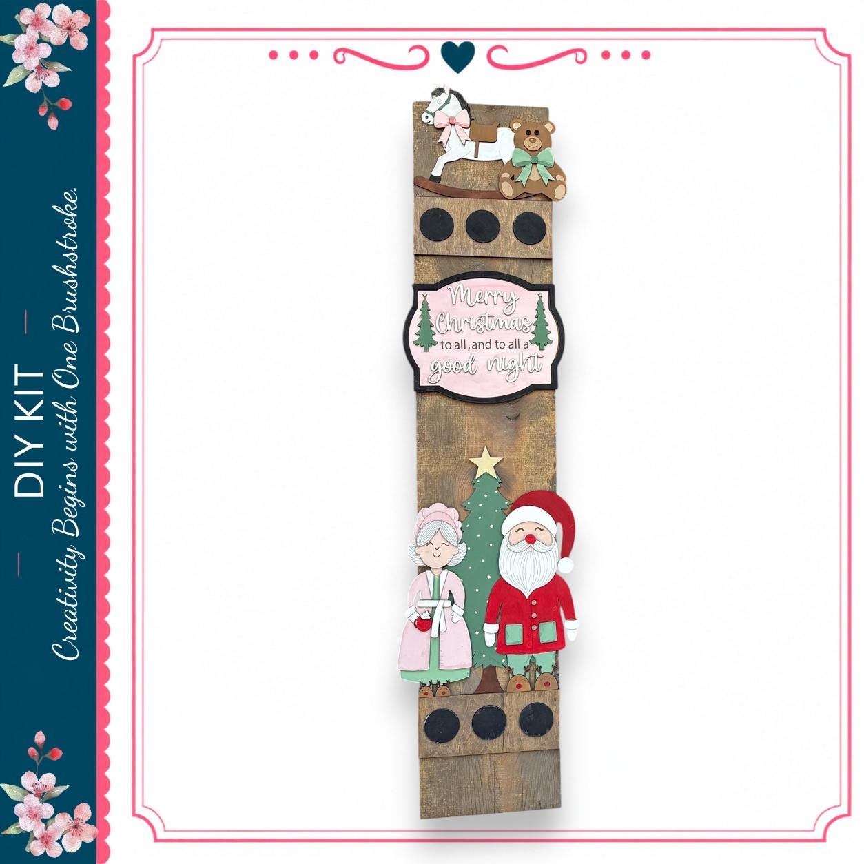 The image is a festive DIY kit featuring a wooden panel with a Christmas tree, Santa Claus, and a teddy bear. The panel also includes a message that reads "Merry Christmas to all and to all a good night".