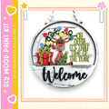 A wooden sign with a festive Christmas theme, featuring a reindeer, a gift, and the text "Welcome" in a cheerful holiday style.