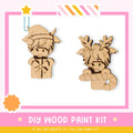 two wooden toys, one resembling a Viking character and the other a reindeer character, both with antlers and a bow. The toys are set against a pink and white background, and there is a text overlay that reads "DIY WOOD PAINT KIT" and "IF WE CAN CREATE IT, YOU CAN MAKE IT!"