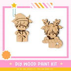 two wooden toys, one resembling a Viking character and the other a reindeer character, both with antlers and a bow. The toys are set against a pink and white background, and there is a text overlay that reads "DIY WOOD PAINT KIT" and "IF WE CAN CREATE IT, YOU CAN MAKE IT!"