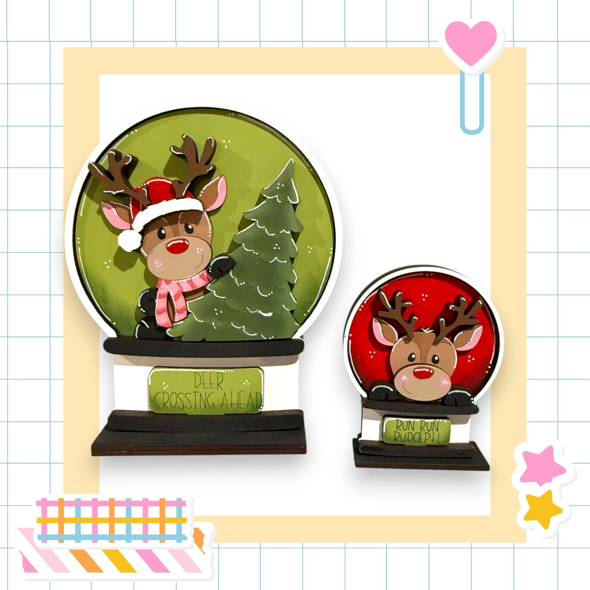 two deer figurines, one larger and one smaller, both wearing Santa hats and standing on a green snow globe. The larger deer is positioned on the left side of the snow globe, while the smaller deer is on the right side. The snow globe is surrounded by a yellow border, and there is a heart-shaped decoration on the right side of the image.