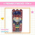 The image is a collage featuring a nutcracker figure surrounded by snowflakes and stars.
