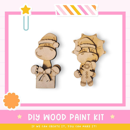 two wooden toys, a dinosaur and a sun, along with a pink and white striped border and a star decoration. The image also includes text that reads "DIY WOOD PAINT KIT" and "IF WE CAN CREATE IT, YOU CAN MAKE IT!"