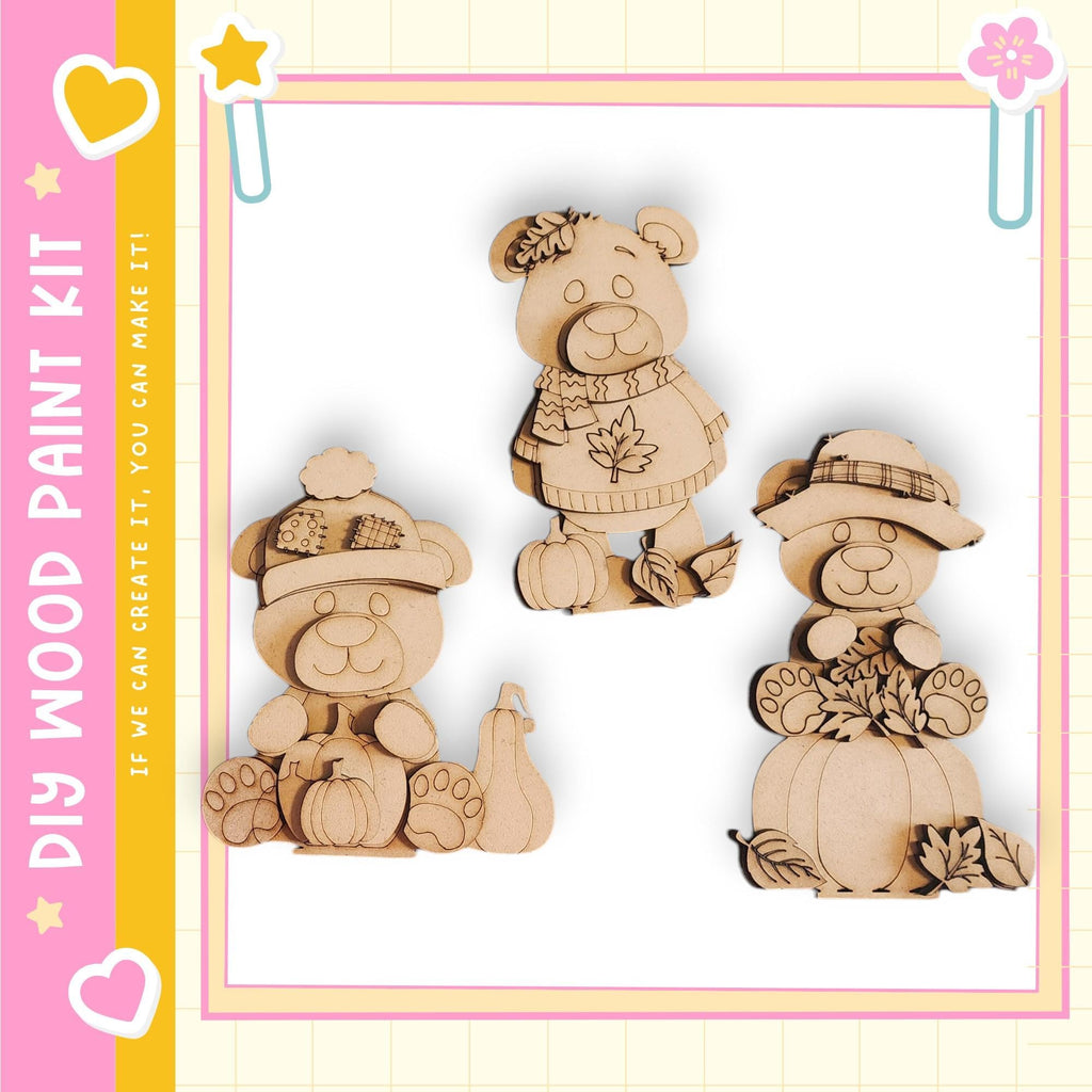 three wooden bear figurines, each with unique accessories such as a hat, scarf, and pumpkin.