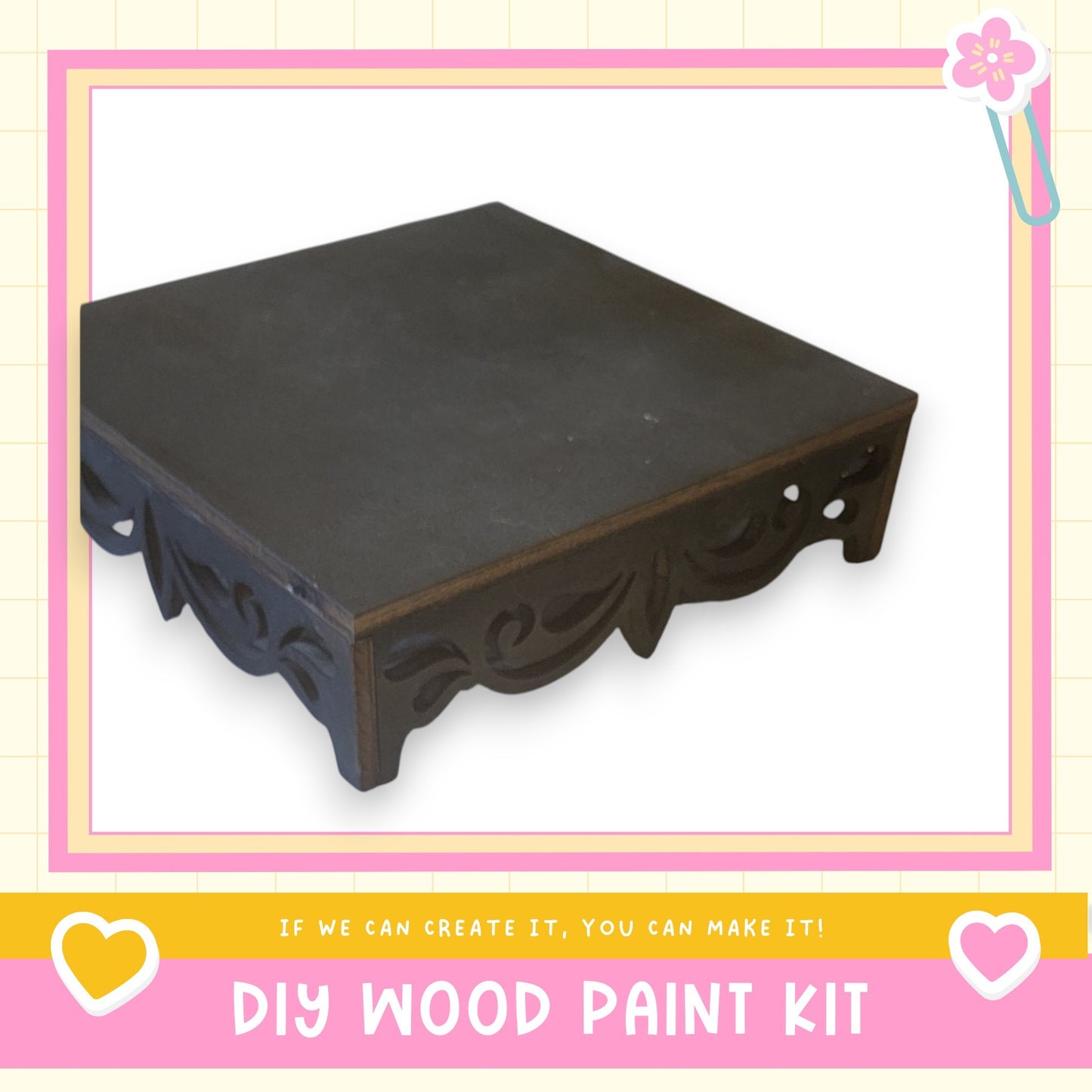 a black wooden table with a decorative design on the legs, presented within a pink and white frame.