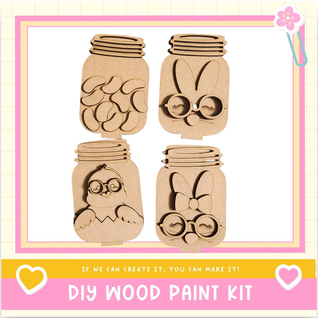 The image is a DIY wood paint kit featuring four wooden mason jars with various animal faces and designs carved into them.