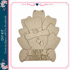 A wooden turkey decoration with the text "GIVE THANKS" on it.