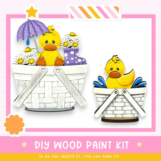 The image is a DIY wood paint kit featuring two cute duck illustrations in baskets, with a pink and white striped border.