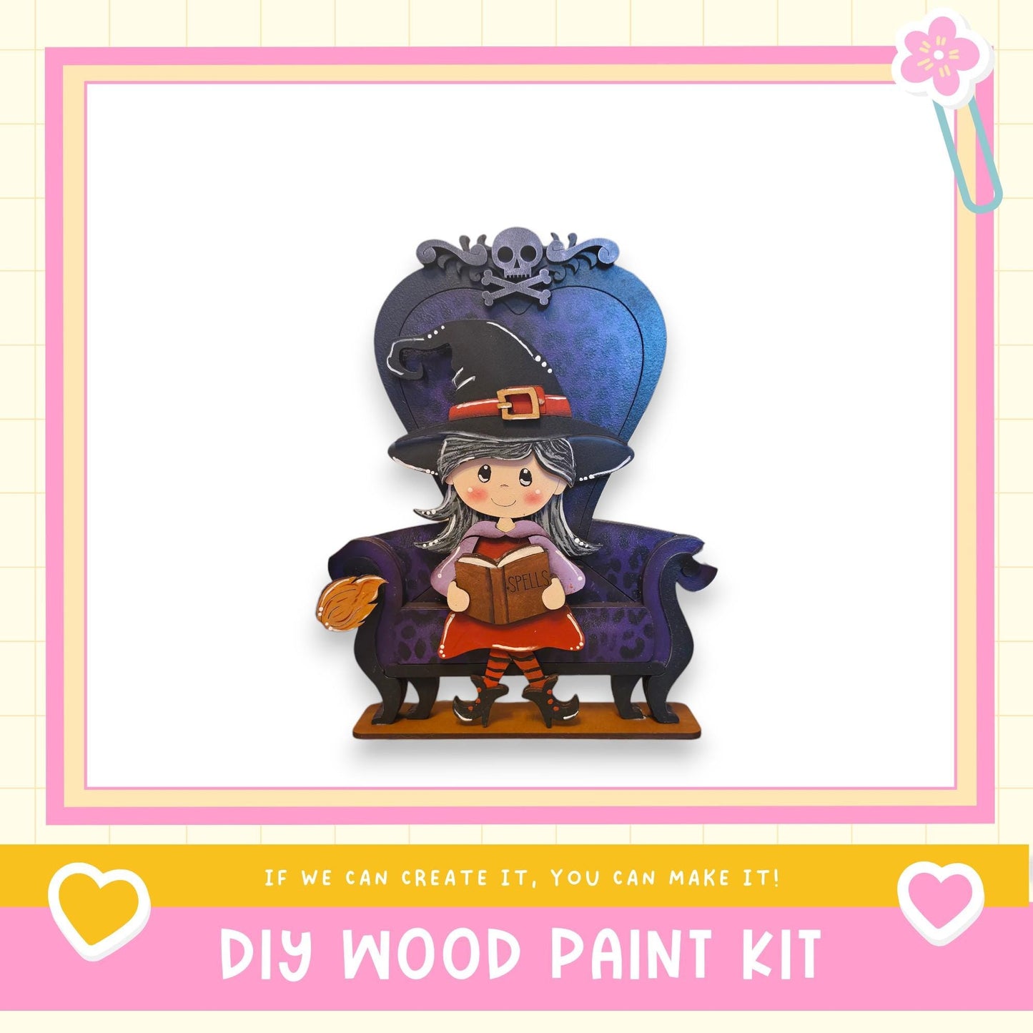 A wooden doll with a witch hat and a book in her hand, sitting on a purple chair.