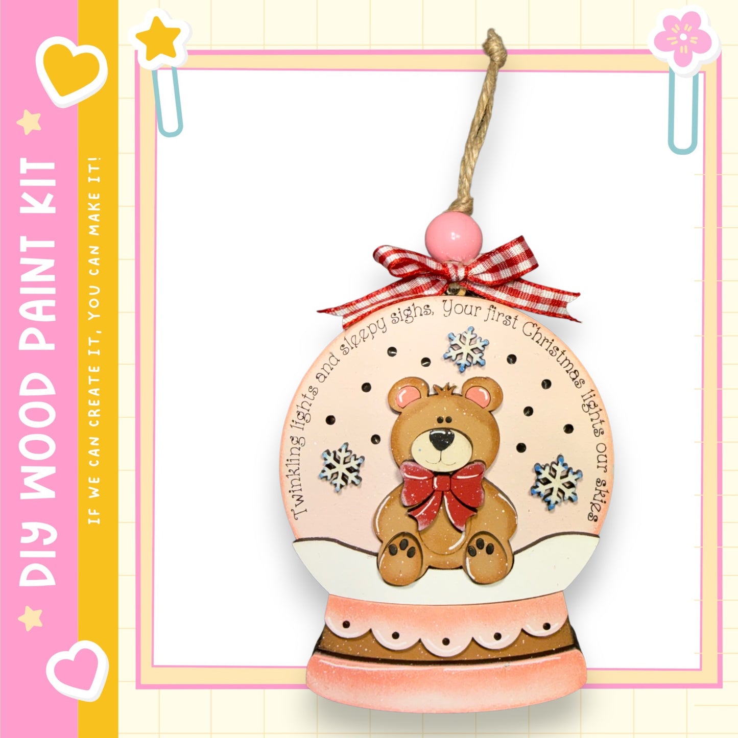 A wooden snow globe ornament with a teddy bear inside, decorated with snowflakes and a red bow.