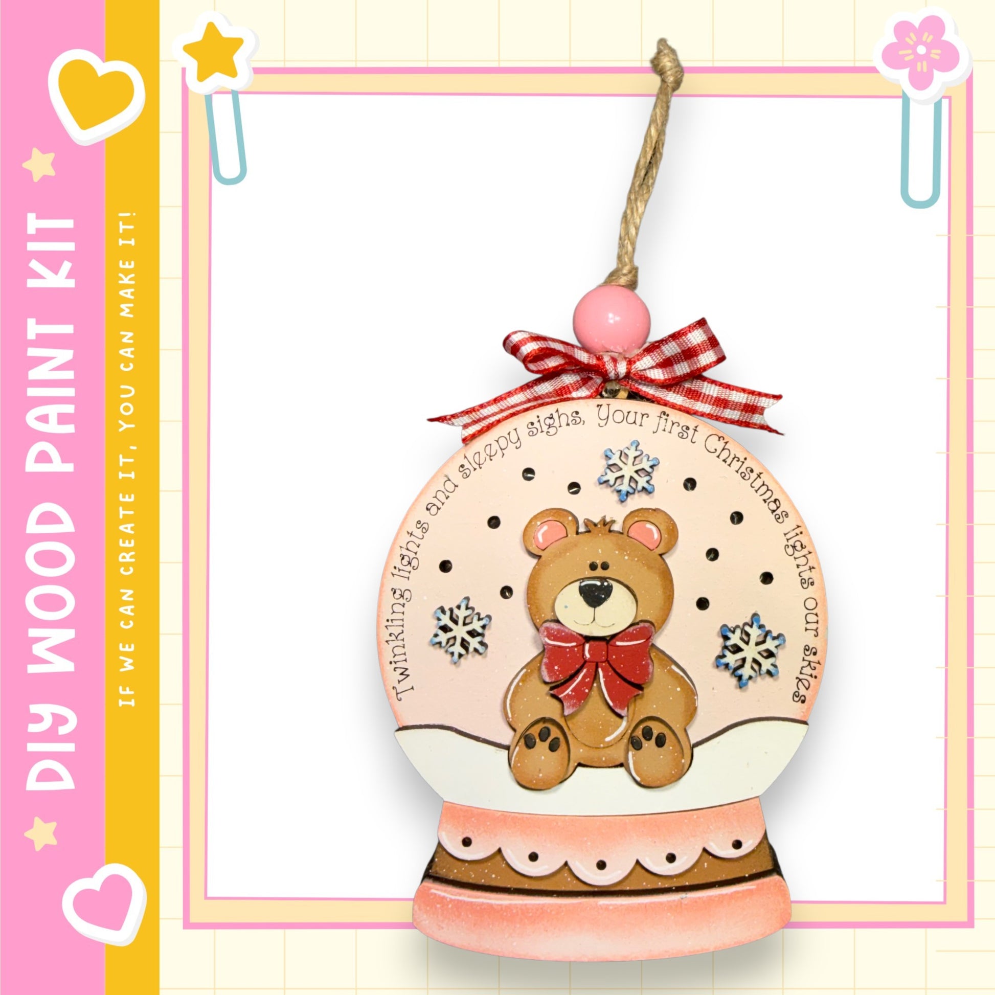 A wooden snow globe ornament with a teddy bear inside, decorated with snowflakes and a red bow.