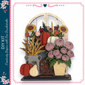 The image is a collage of various fall-themed elements, including a wooden archway, a vase of flowers, pumpkins, and a spindle wheel.
