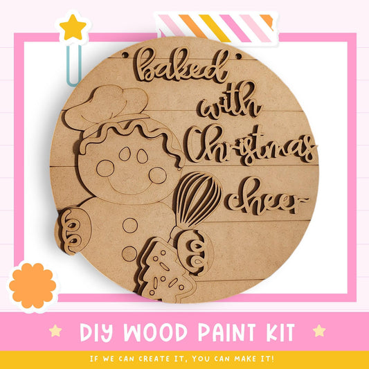 The image is a DIY wood paint kit for creating a wooden sign with a baked with Christmas cheer design.