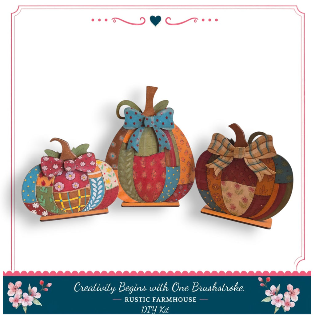 three decorative pumpkins with bows, arranged in a row against a white background.
