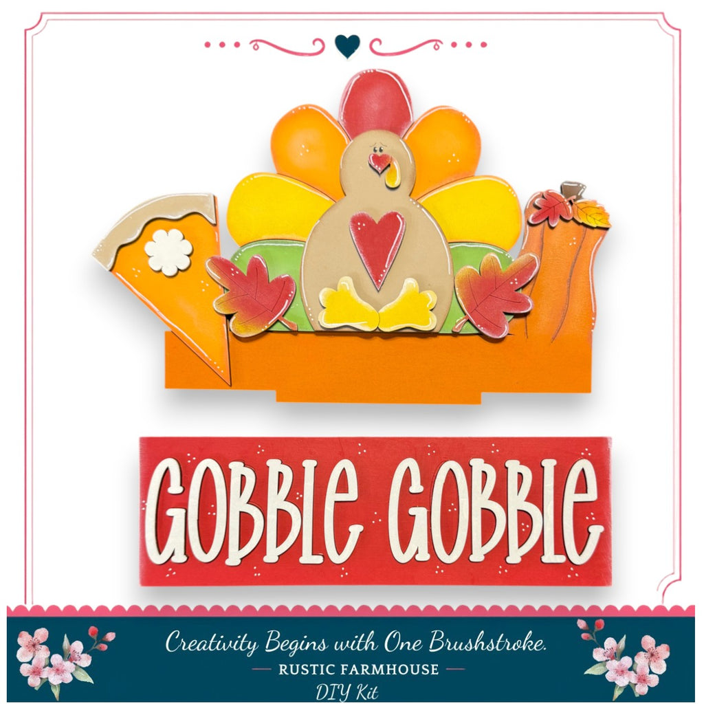 The image is a promotional image for a DIY turkey decoration kit. It features a colorful turkey figure with a pie and pumpkins, along with the text "GOBBLE GOBBLE" and "Creativity Begins with One Brushstroke - Rustic Farmhouse - DIY Kit".