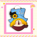 A colorful and whimsical scarecrow-like figure with a blue hat, yellow scarf, and a bird perched on top, set against a pink and yellow checkered background with stars and a rainbow.