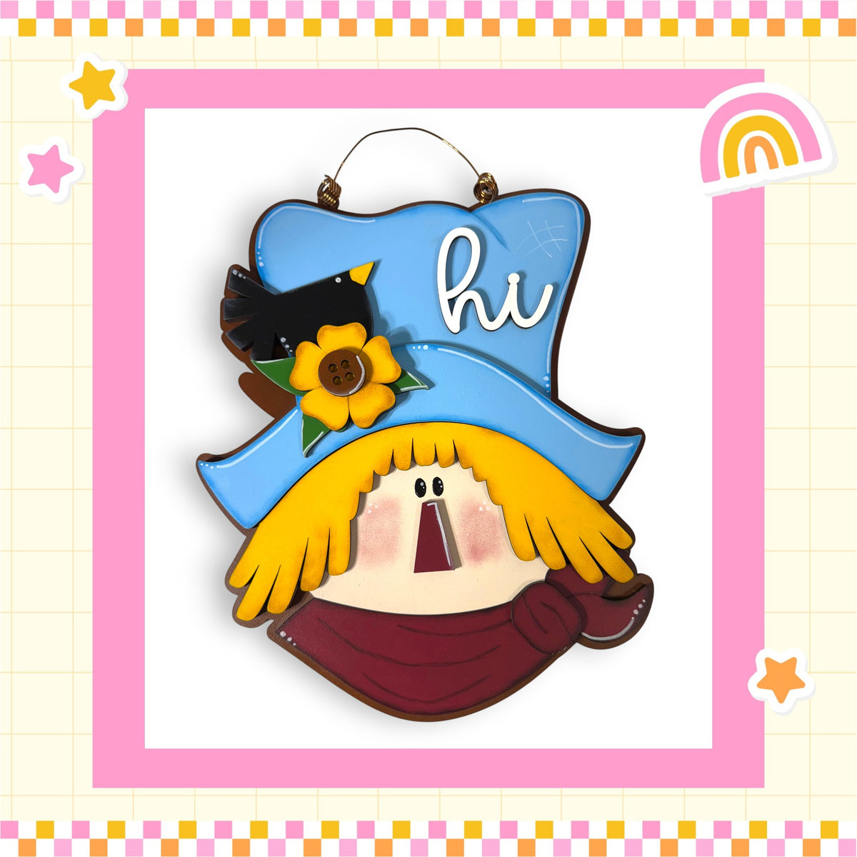 A colorful and whimsical scarecrow-like figure with a blue hat, yellow scarf, and a bird perched on top, set against a pink and yellow checkered background with stars and a rainbow.