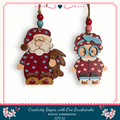 two wooden ornaments hanging from a string, depicting Santa Claus and a young girl.