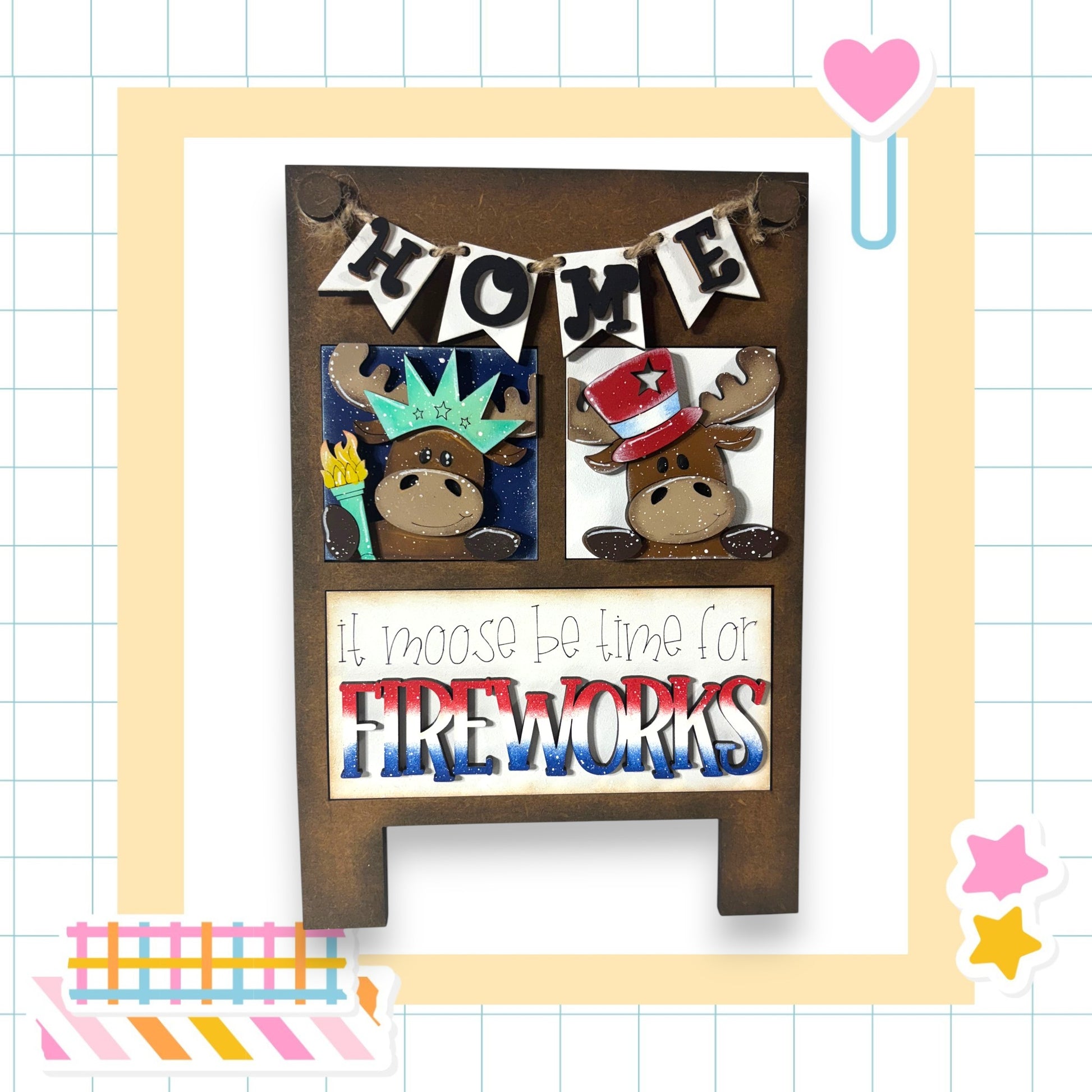 The image is a wooden sign with a moose and a star, featuring the text "Home" and "It moose be time for fireworks" in a playful and festive style.