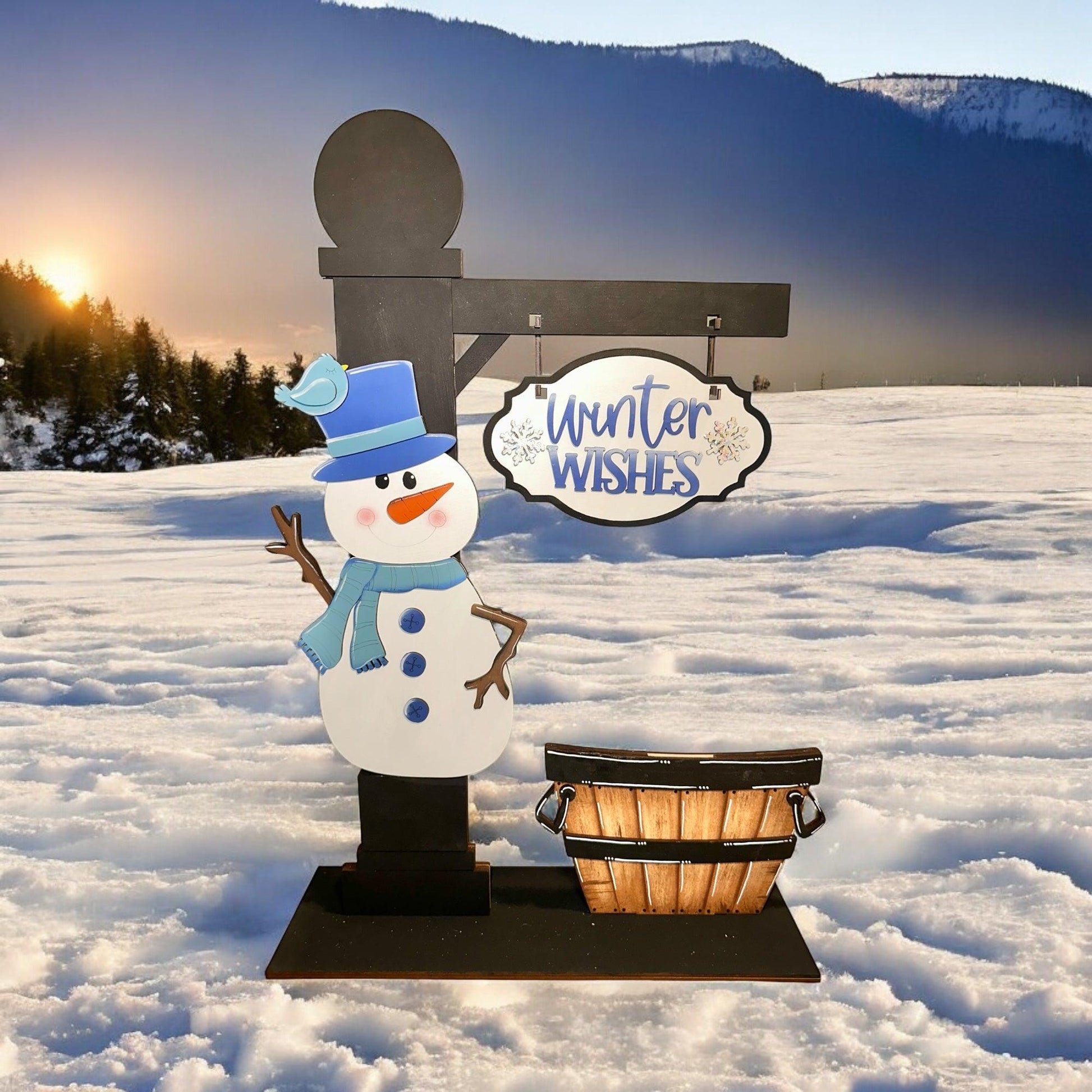 a snowman standing next to a basket in the snow