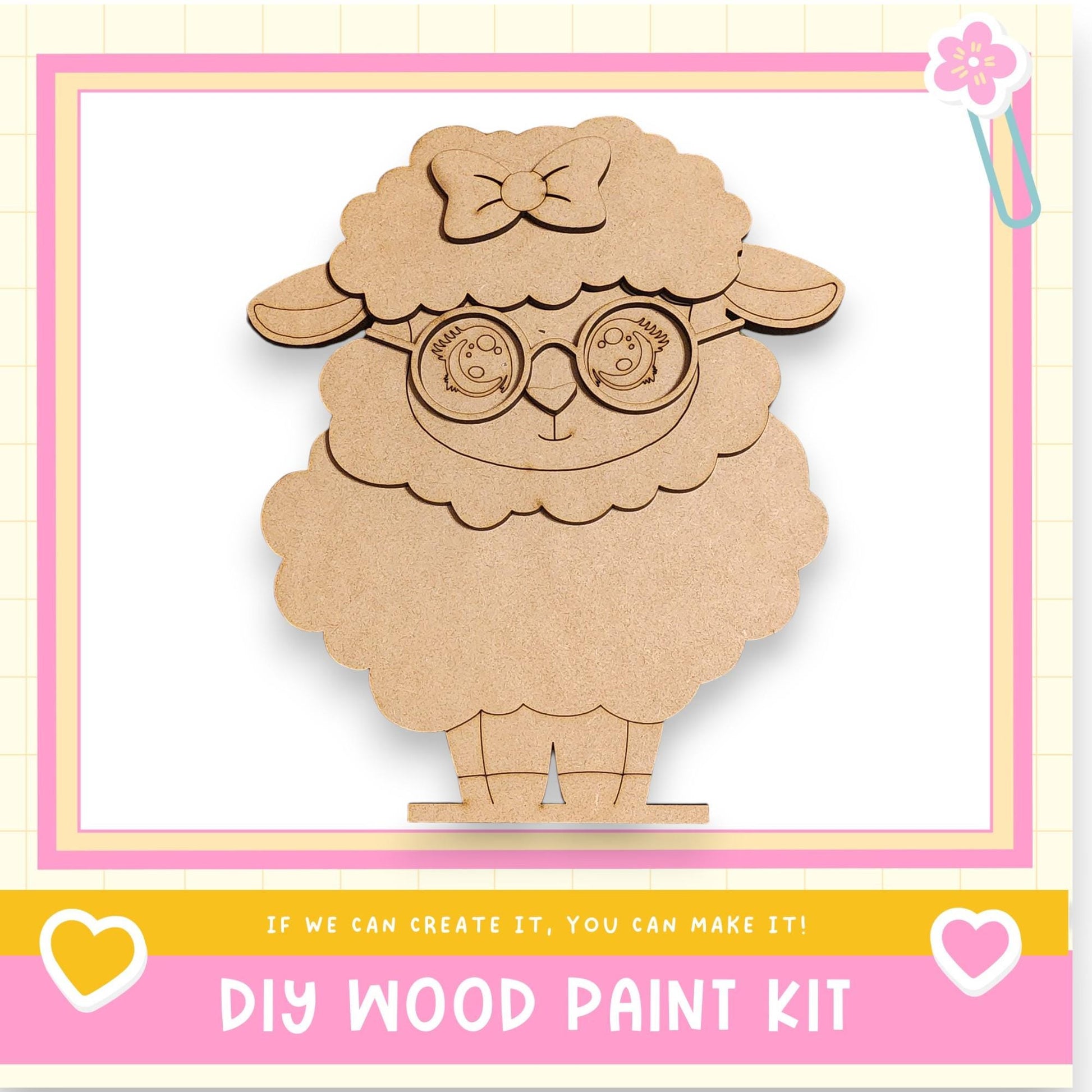 a wooden sheep-shaped object with a bow on its head, sitting on a pink and yellow background.